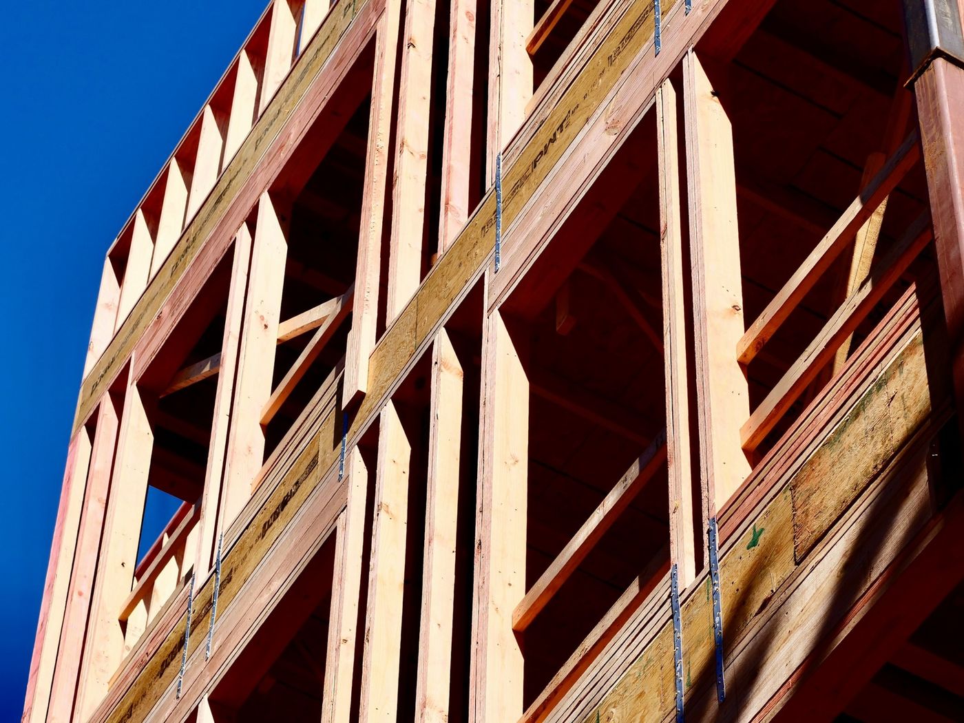 Holzrahmenbau eines mehrstöckigen Hauses vor blauem Himmel